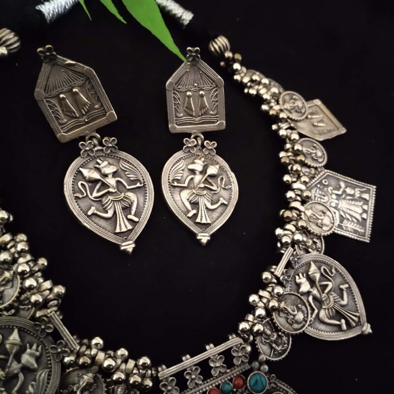 Elegant Indian tribal jewelry set featuring silver necklace and earrings with traditional deity motifs, perfect for Indian fashion jewelry enthusiasts and cultural festivals.