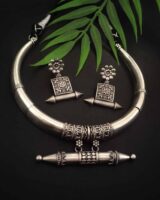 Silver ethnic jewelry set including a choker necklace and matching earrings with intricate traditional designs, perfect for Indian fashion jewelry enthusiasts.