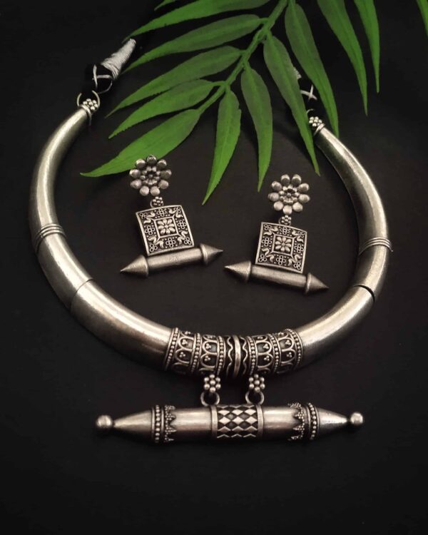 Silver ethnic jewelry set including a choker necklace and matching earrings with intricate traditional designs, perfect for Indian fashion jewelry enthusiasts.