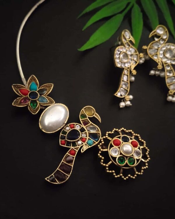 Colorful traditional Indian jewelry set with peacock and floral motifs, featuring pearls, colored stones, and intricate gold plating, perfect for festive occasions and cultural celebrations.