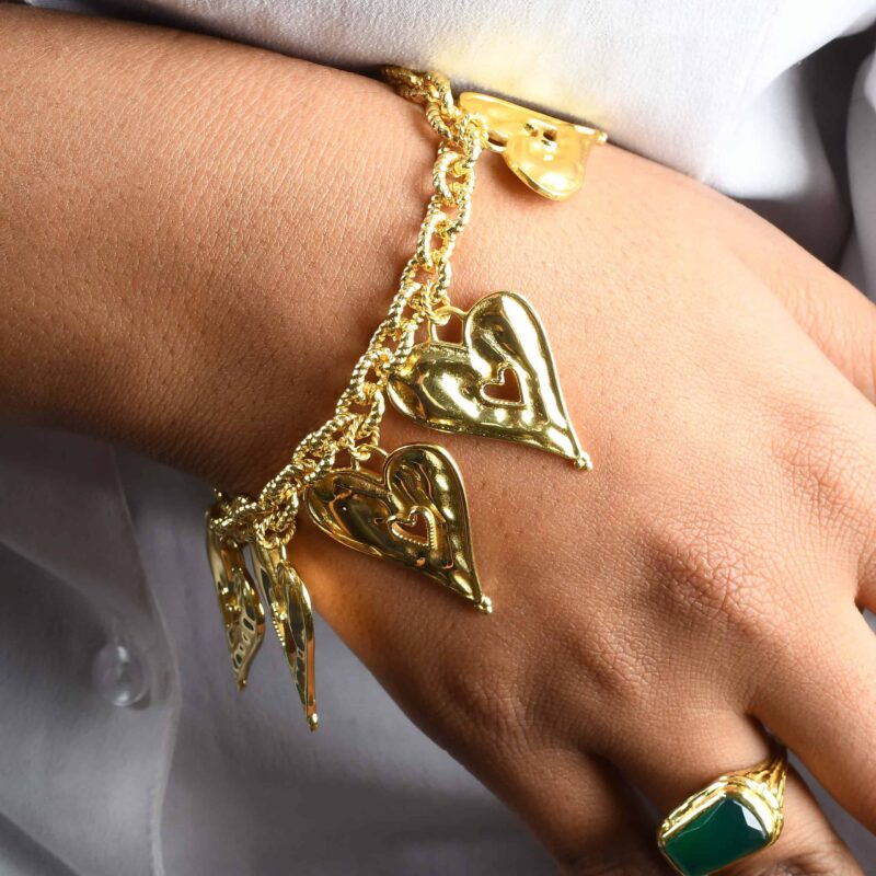 Gold heart-shaped jewelry bracelet with intricate design, worn on a person's wrist. Perfect for traditional Indian fashion jewelry collections on Kurabels.com.