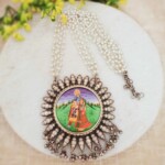 Traditional Indian jewelry necklace with colorful deity pendant and pearl beads for ethnic festive look.