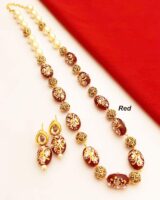 Elegant Indian jewelry set featuring red beads and gold-tone accents with intricate white detailing, perfect for traditional occasions and festive celebrations.