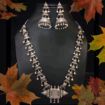 Intricate silver tribal jewelry set including a necklace and jhumka earrings, showcasing traditional Indian craftsmanship. Perfect for ethnic occasions and adding elegance to your attire.