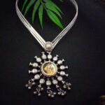 Intricate silver necklace with traditional Indian artwork pendant, adorned with decorative silver beads and hanging charms, perfect for ethnic jewelry collection.