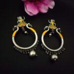Elegant Indian traditional earrings with peacock motifs and colorful enamel accents, perfect for ethnic jewelry collections, crafted with silver-tone metal, ideal for festive & special occasions.