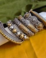 Intricate Indian fashion jewelry bracelets and bangles set featuring traditional silver and gold-toned designs with detailed craftsmanship, perfect for ethnic wear.