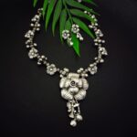 Intricate silver floral jewelry set featuring a necklace and matching earrings, designed with traditional Indian craftsmanship, perfect for ethnic Indian fashion jewelry enthusiasts.