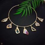 Elegant gold plaited necklace with multi-colored gemstone pendants, perfect for Indian fashion jewelry and ethnic wear, showcasing stylish and traditional jewelry designs.