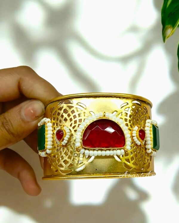 Elegant Indian jewelry bracelet with red, green, and white embellishments, showcasing intricate gold design for traditional festive occasions and stylish wear.