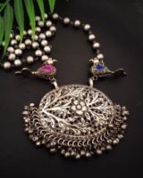 Intricate silver neckpiece with floral design, adorned with small hanging beads, perfect for traditional Indian jewelry looks.