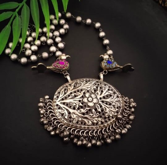 Intricate silver neckpiece with floral design, adorned with small hanging beads, perfect for traditional Indian jewelry looks.