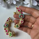 Vibrant traditional Indian jewelry set with gold-tone finish, colorful stones, pearls, and intricate design, perfect for festivals and weddings.