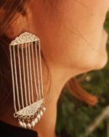 Elegant silver Indian jewelry earring with intricate floral design, dangling pearls, and bar chain details, perfect for traditional or festive occasions.