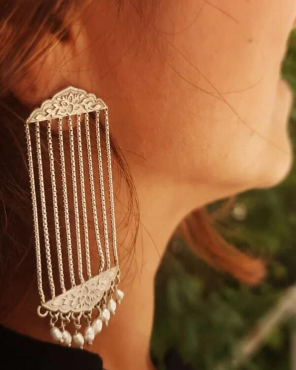 Elegant silver Indian jewelry earring with intricate floral design, dangling pearls, and bar chain details, perfect for traditional or festive occasions.