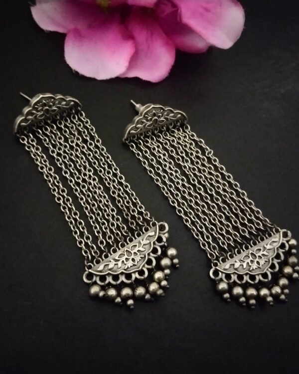 Intricate silver Indian earrings with hanging chains and floral design, perfect for traditional jewelry or festive occasions.