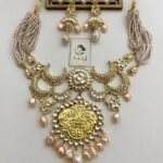 Elegant Indian jewelry set with gold-plated necklace and matching earrings featuring pearl accents, intricate design, perfect for traditional occasions and festive wear.