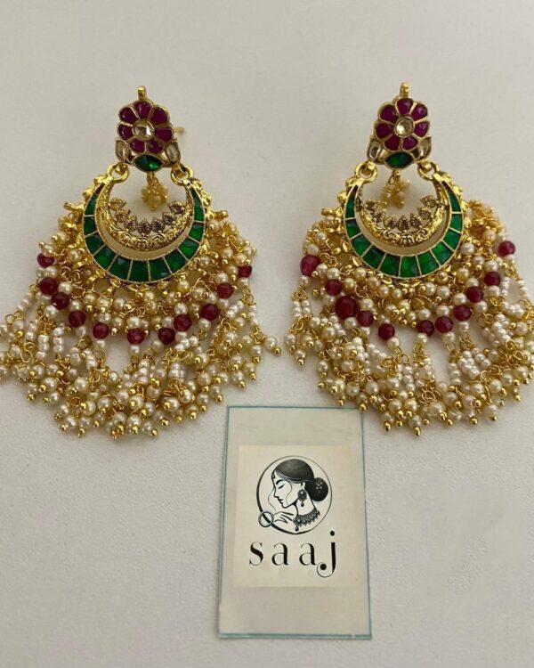 Bright Indian jewelry earrings featuring gold-plated designs, green enamel, pearls, and red beads, perfect for traditional Indian fashion and festive occasions.