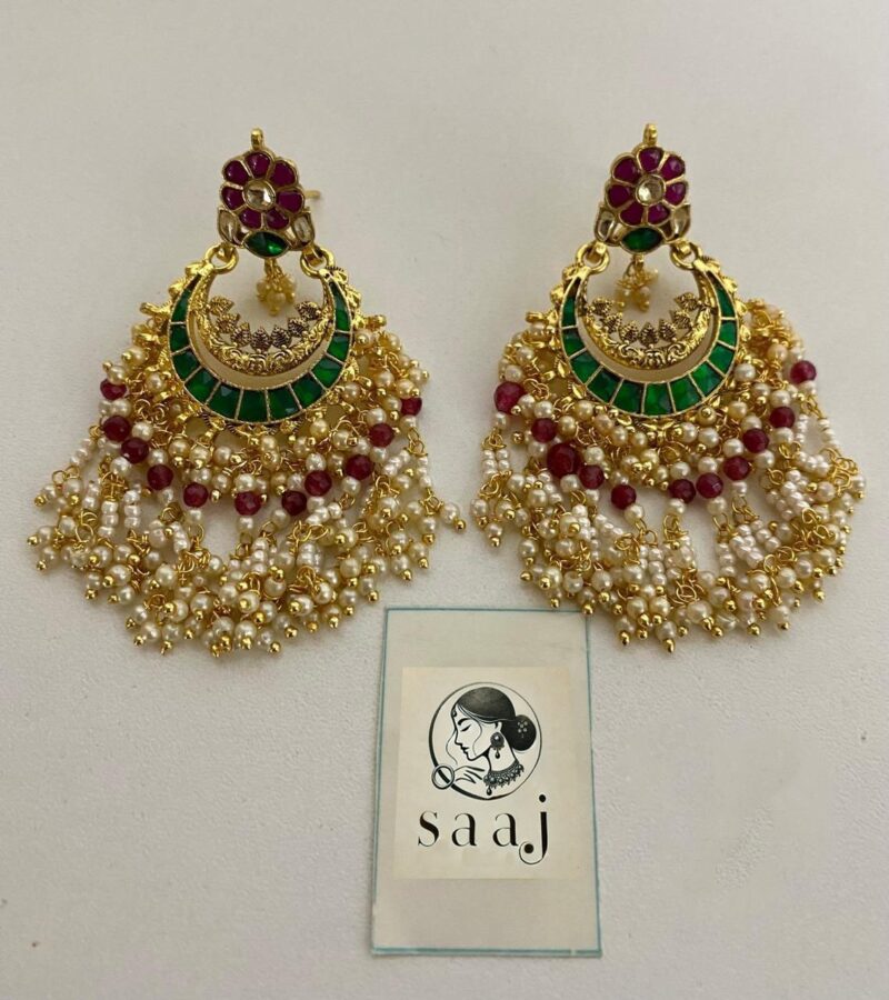 Bright Indian jewelry earrings featuring gold-plated designs, green enamel, pearls, and red beads, perfect for traditional Indian fashion and festive occasions.