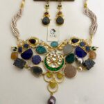 Colorful Indian fashion jewelry set with statement necklace and matching earrings, featuring multicolored gemstones, pearls, and gold accents, perfect for traditional or festive occasions.