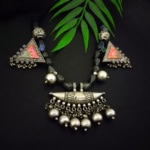 Antique tribal silver and onyx necklace with vibrant enamel accents, intricate detailing, and dangling silver beads for a traditional Indian jewelry look.