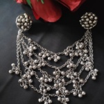 Silver traditional Indian jewelry necklace with dangling bead embellishments and intricate chain design, perfect for festive and cultural occasions.