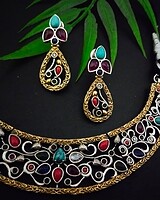 Intricate Indian jewelry set including a gold-tone necklace and matching earrings with colorful stones, perfect for traditional occasions and festive celebrations.