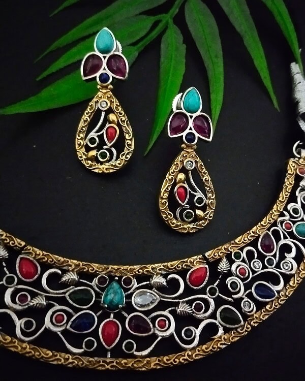 Intricate Indian jewelry set including a gold-tone necklace and matching earrings with colorful stones, perfect for traditional occasions and festive celebrations.