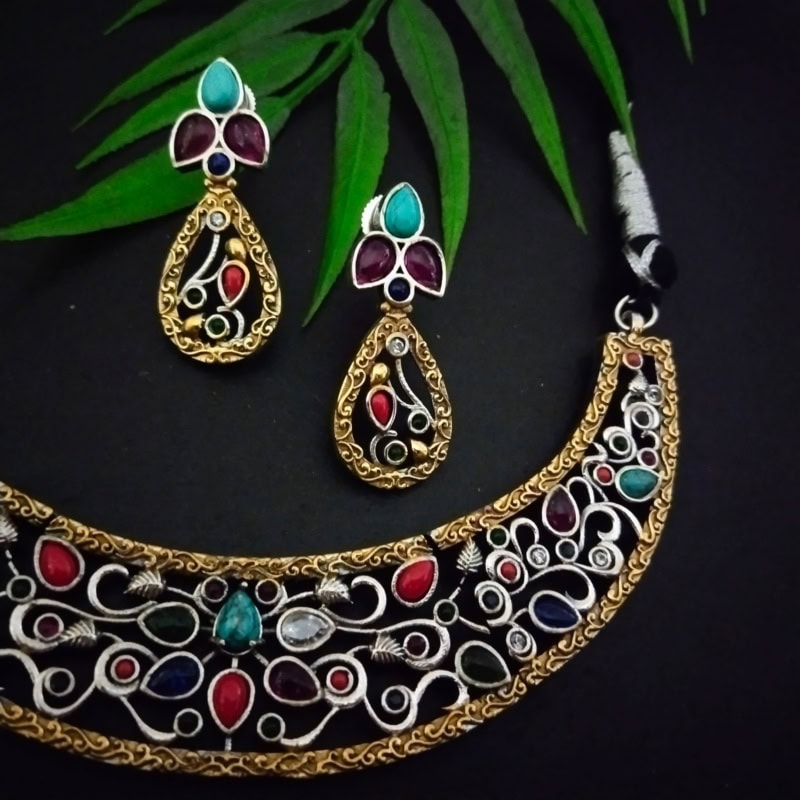 Intricate Indian jewelry set including a gold-tone necklace and matching earrings with colorful stones, perfect for traditional occasions and festive celebrations.