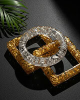 Shimmering acrylic bangles in silver and gold tones with textured designs, perfect for ethnic Indian jewelry looks, displayed on a black surface with a green leaf accent.