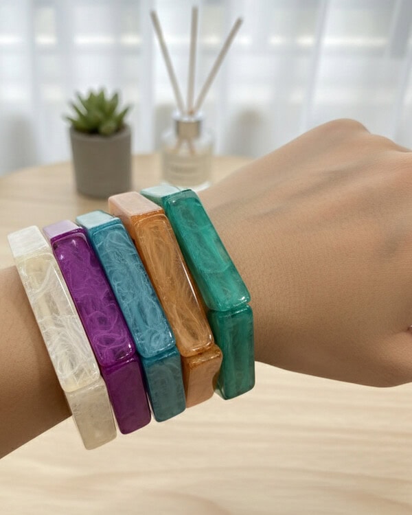 Colorful resin bangles on a wrist, showcasing vibrant jewelry accessories from Kurabels, an Indian fashion jewelry online store.
