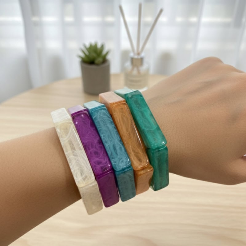 inbound2986973504632543384 Colorful resin bangles on a wrist, showcasing vibrant jewelry accessories from Kurabels, an Indian fashion jewelry online store.