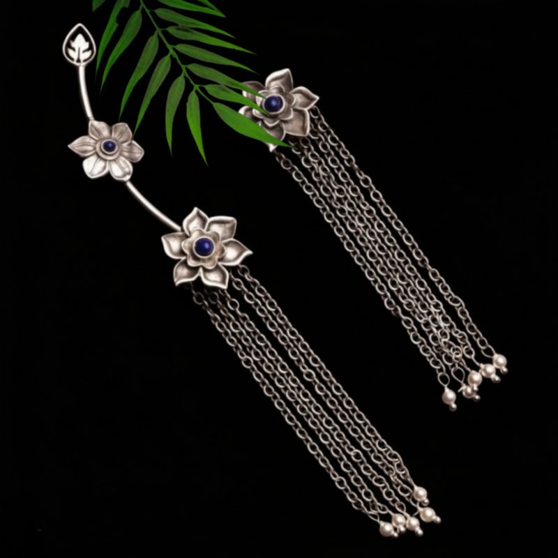 Elegant silver floral jewelry set with blue gemstone centers and dangling chains, perfect for traditional Indian jewelry styling and special occasions.