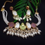 Elegant Indian jewelry set featuring pearl and gemstone embellishments, including a necklace and matching earrings, perfect for traditional festive and wedding occasions.