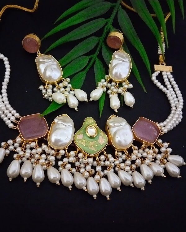 Elegant Indian jewelry set featuring pearl and gemstone embellishments, including a necklace and matching earrings, perfect for traditional festive and wedding occasions.