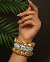 Glamorous Indian fashion jewelry stacked bangles on a feminine wrist, featuring gold and silver textured finishes, perfect for traditional or modern outfits.
