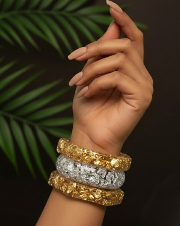 Glamorous Indian fashion jewelry stacked bangles on a feminine wrist, featuring gold and silver textured finishes, perfect for traditional or modern outfits.