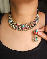 Intricately designed Indian jewelry set featuring a statement necklace and matching earrings with colorful gemstones, perfect for traditional occasions and cultural festivals.