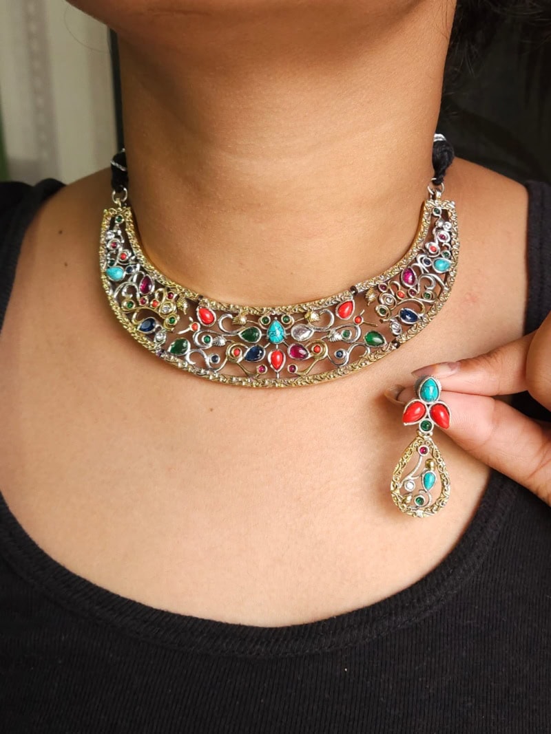 Intricately designed Indian jewelry set featuring a statement necklace and matching earrings with colorful gemstones, perfect for traditional occasions and cultural festivals.