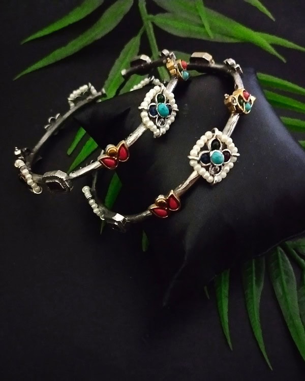 Intricate traditional Indian jewelry set featuring colorful stones, pearls, and silver craftsmanship, perfect for festive or wedding occasions.