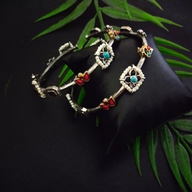 Intricate traditional Indian jewelry set featuring colorful stones, pearls, and silver craftsmanship, perfect for festive or wedding occasions.