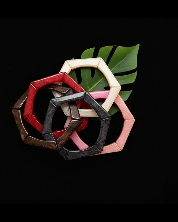 Colorful wooden bangles stacked together with green tropical leaf on black background, perfect for Indian jewelry and fashion accessories.