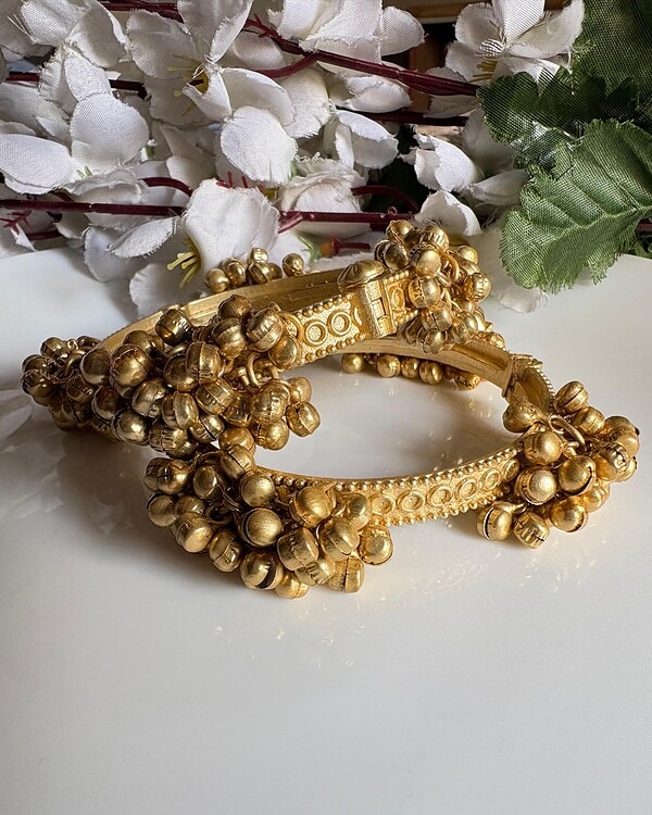 Gold traditional Indian jewelry choker with intricate designs and dangling bead embellishments, perfect for festive occasions and cultural celebrations.