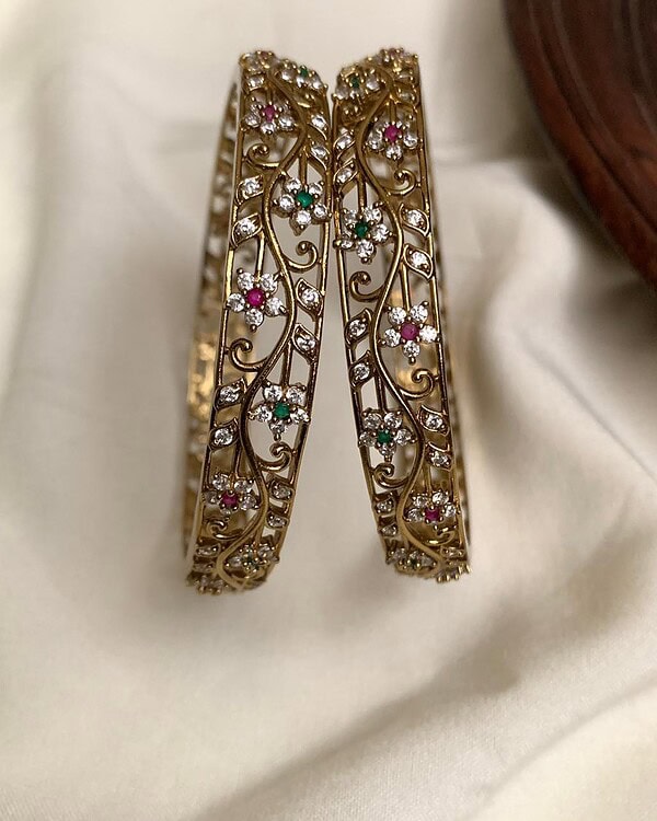 Elegant gold and gemstone floral bangles with intricate design and sparkling accents, perfect for Indian traditional jewelry and special occasions.
