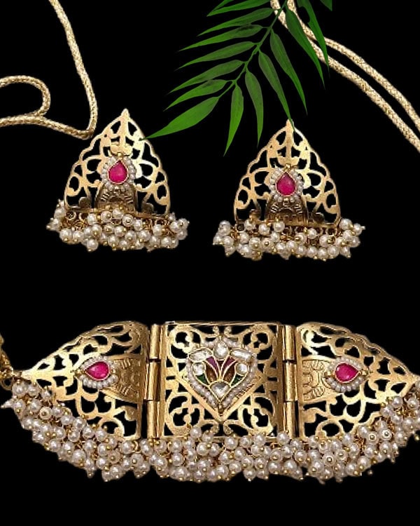 Exquisite gold necklace and matching earrings set with pearls and pink gemstone details, ideal for traditional Indian jewelry lovers and special occasions.